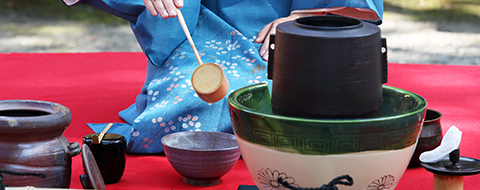 A tea ceremony setting with iron kettle and tea bowl